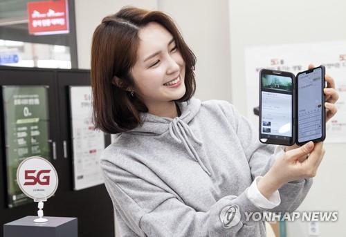 A model shows off LG Electronics Inc.'s V50 ThinQ at an outlet in Seoul in this photo provided by SK Telecom Co. on May 10, 2019. (PHOTO NOT FOR SALE) (Yonhap) 