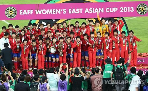In this file photo from July 27, 2013, members of the South Korean and North Korean women's national football teams pose for group photos during the medal ceremony of the East Asian Football Federation Women's East Asian Cup at Jamsil Olympic Stadium in Seoul. North Korea won and South Korea finished in third place. (Yonhap)
