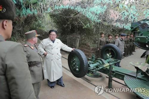 Putting his hand on military equipment believed to be a coastal gun, North Korean leader Kim Jong-un (3rd from L) talks with soldiers during a visit to a defense detachment on Changrin Islet near the western sea border with South Korea, in this photo provided by the Korean Central News Agency on Nov. 25, 2019. The agency stopped short of reporting when he made the visit. (For Use Only in the Republic of Korea. No Redistribution) (Yonhap)