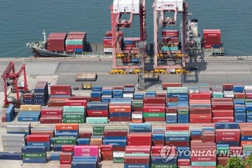 The file photo, taken May 14, 2019, shows stacks of export containers being loaded onto a ship at South Korea's largest seaport in Busan, located some 450 kilometers southeast of Seoul. (Yonhap)