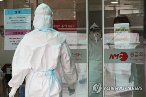 Medical workers at the National Medical Center wear protective masks and suits as they prepare to check people for the novel coronavirus on Jan. 29, 2020. (Yonhap)