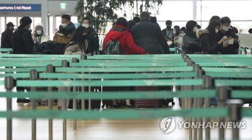 Passengers wearing face masks wait near a departure gate of Incheon International Airport, west of Seoul, on Feb. 2, 2020. (Yonhap)