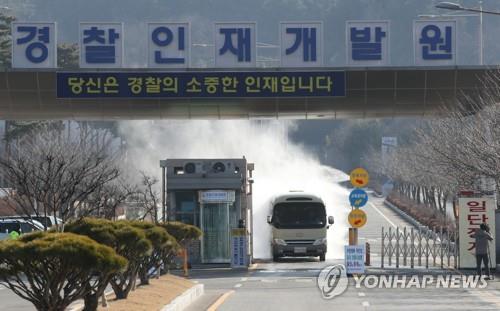 A vehicle is disinfected at the Police Human Resources Development Institute, a temporary shelter for South Korean evacuees from the Chinese city of Wuhan, in Asan on Feb. 11, 2020. (Yonhap)