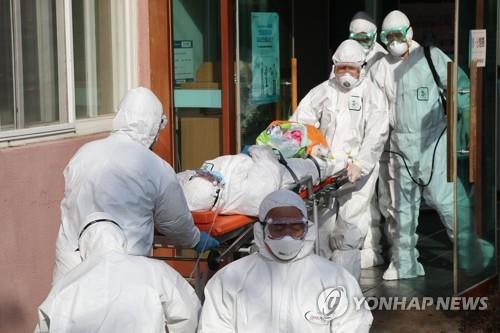 Medical workers transfer a suspected coronavirus patient from Daenam Hospital in Cheongdo, 320 kilometers southeast of Seoul, to another hospital on Feb. 21, 2020. (Yonhap)