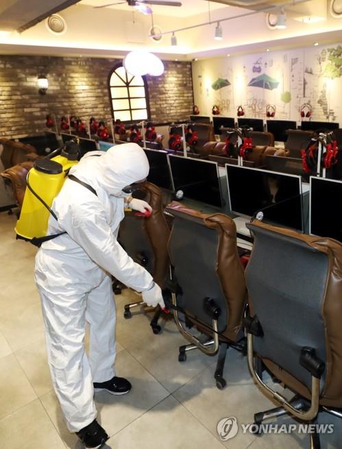 A public official disinfects a Korean-style internet cafe, known as a "PC bang," in Incheon, west of Seoul on March 13, 2020, amid the spread of the new coronavirus. (Yonhap)