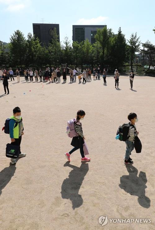 Students keep a distance from one another after arriving at Cheongun Elementary School in Seoul on May 27, 2020, amid the coronavirus pandemic. (Yonhap)