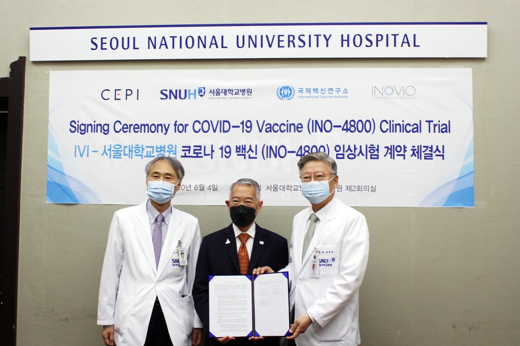 Seoul National University President Kim Yon-su (R) and professor Oh Myoung-don (L) and Jerome Kim (C), director general of the IVI, pose for a photo at the signing ceremony for COVID-19 vaccine clinical trials in Seoul on June 4, 2020, in this photo provided by the International Vaccine Institute (IVI). 
