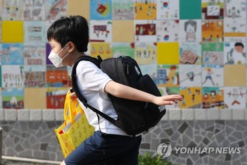 A young student runs toward a school in Seoul's Yongsan Ward on June 8, 2020, as schools reopen in full swing. (Yonhap)