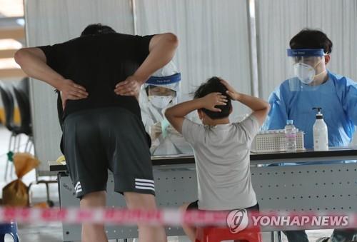A child waits to receive a new coronavirus test at a makeshift clinic in Gwangju, 330 kilometers southwest of Seoul, on July 5, 2020. (Yonhap)