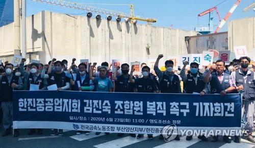 Kim Jin-suk (5th from left) and unionized workers of Hanjin Heavy Industries & Construction Co. shout a slogan, holding a banner announcing press conference to urge the shipbuilder to get Kim back to work in front of the main gate of the shipbuilder on June 23, 2020. (Yonhap)