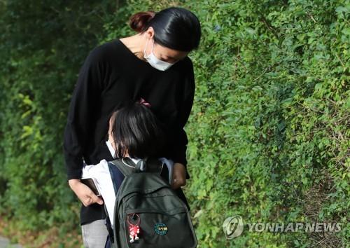 An elementary student hugs her mother before entering a school in Seoul on Sept. 21, 2020. (Yonhap)