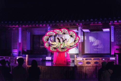 This photo, provided by the Cultural Heritage Administration, shows dancers performing a traditional dance using fans during a nighttime tour of Changdeok Palace in central Seoul. (PHOTO NOT FOR SALE) (Yonhap) 