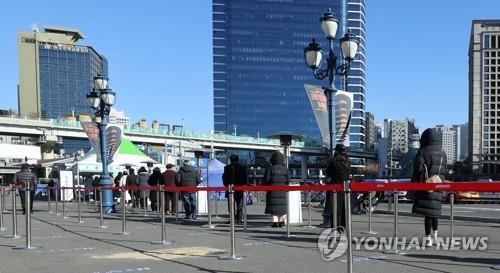 People stand in line to take coronavirus tests at a temporary screening center in front of Seoul Station in central Seoul on Dec. 16, 2020. (Yonhap)