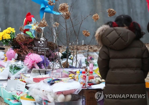 A child pays tribute at the grave site where a 16-month-old girl was buried in Yangpyeong, Gyeonggi Province, on Jan. 4, 2021. (Yonhap)