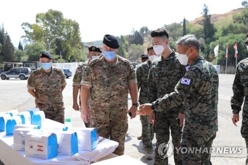 Col. Kim Do-young (R) who commands South Korea's Dongmyung Unit in Lebanon, delivers emergency relief items to Lebanese officers on Aug. 8, 2020, to help the country recover from a recent massive explosion, in this photo provided by South Korea's defense ministry. (PHOTO NOT FOR SALE) (Yonhap)