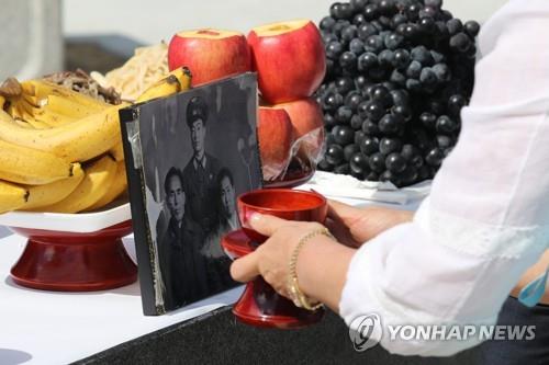 In this file photo, a woman offers a glass of wine before a black and white photo during a joint ancestral rite for North Korean defectors at Imjingak Park in Paju, just south of the Demilitarized Zone separating the Koreas. (Yonhap)