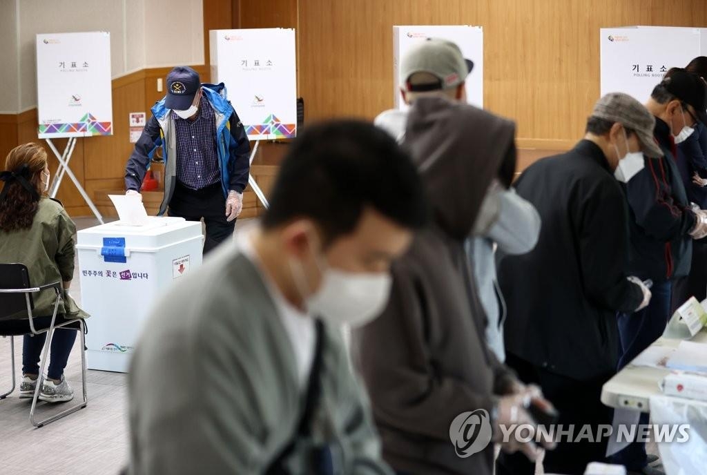 People cast their ballots at a polling station in Seoul on April 7, 2021. (Yonhap)