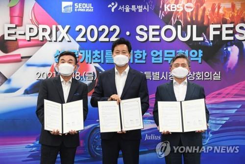 Seoul Mayor Oh Se-hoon (C) poses with the heads of Formula E Korea and public broadcaster KBS at his office on June 18, 2021, after signing a three-party cooperation agreement for the success of Seoul E-Prix 2022, in this photo provided by Oh's government. (PHOTO NOT FOR SALE) (Yonhap)