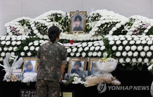 In this file photo, a service member mourns at a memorial altar on June 11, 2021, for a noncommissioned officer who took her own life after being sexually harassed by a colleague. (Yonhap)