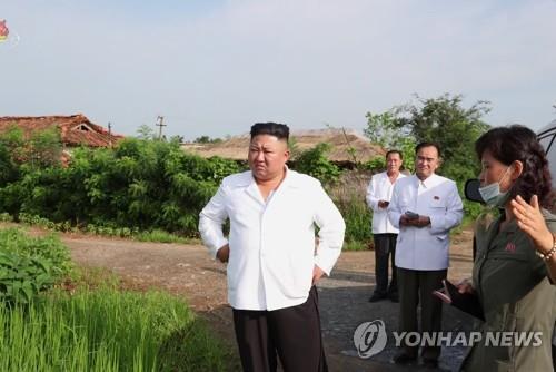 In this file photo captured from the Korean Central Television Broadcasting Station on Aug. 7, 2020, North Korean leader Kim Jong-un (C) with a grave look listens to an official during a visit to a flood-ravaged village in Unpha, North Hwanghae Province. (For Use Only in the Republic of Korea. No Redistribution) (Yonhap)