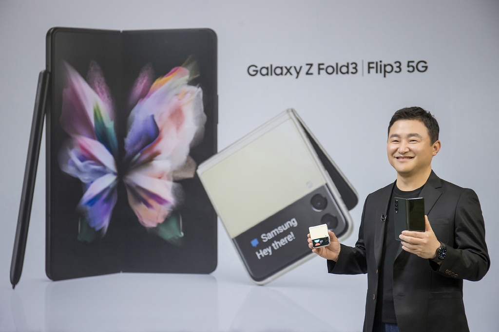 This photo provided by Samsung Electronics Co. on Aug. 11, 2021, shows Roh Tae-moon, head of Samsung's mobile communications business, holding the Galaxy Z Fold3 and the Galaxy Z Flip 3 at the Galaxy Unpacked event. (PHOTO NOT FOR SALE) (Yonhap)