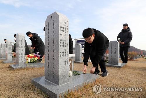 This file photo shows students laying flowers at the tombs of volunteer fighters who defended South Korea's easternmost islets of Dokdo at a national cemetery in Daejeon, 160 kilometers south of Seoul, in November 2019. (Yonhap)