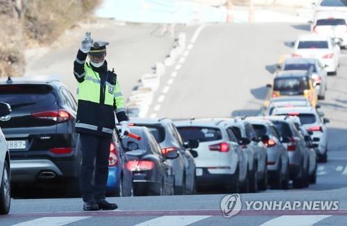 Cars wait in line to get to a drive-through testing site for the coronavirus in Incheon, west of Seoul, on Dec. 6, 2021. (Yonhap) 