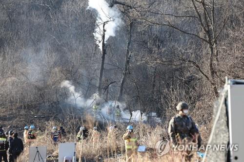 Military officials check the wreckage of an F-5E fighter on a hill in Hwaseong, about 40 kilometers south of Seoul, where the plane belonging to the Air Force's 10th Combat Squadron crashed shortly after takeoff at 1:44 p.m. on Jan. 11, 2022. (Yonhap)