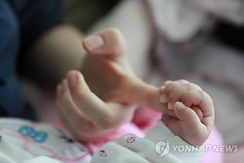 This undated file photo shows a baby holding the mother's finger. (Yonhap)