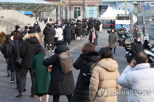 People wait in line to get tested for the coronavirus at a makeshift clinic in central Seoul on Feb. 8, 2022. (Yonhap)
