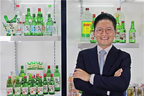 Hwang Jung-ho, managing director in charge of Hitejinro's overseas business, poses for the camera in front of the company's main distilled liquor soju products after an interview with Yonhap News Agency at the company's head office in Seocho, southern Seoul on May 20, 2022. (Yonhap)