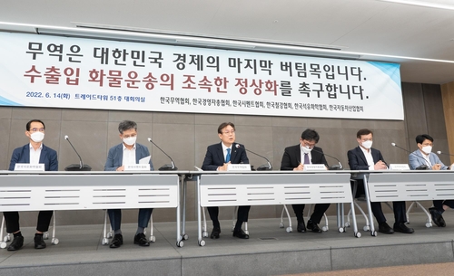 This photo provided by the Korea International Trade Association (KITA) on June 14, 2022, shows KITA Vice Chairman Lee Kwan-sup (3rd from L) and officials from various industry associations holding a press conference in Seoul urging truckers to end their strike leading to massive cargo disruptions in South Korea. (PHOTO NOT FOR SALE) (Yonhap) 