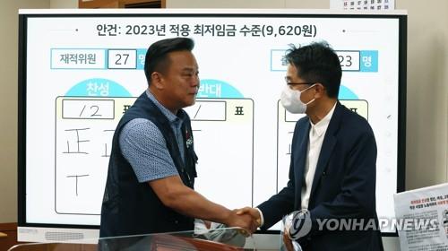 Park Joon-shik (R), head of the Minimum Wage Commission, shakes hands with Lee Dong-ho, secretary general of the Federation of Korean Trade Unions, at the government complex in Sejong, central South Korea, on June 29, 2022, after attending the commission's eighth plenary session. (Yonhap)