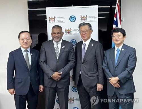 Cho Dae-sik (2nd from R), head of SK Group's Supex Council, the top decision-making body, and other SK officials pose for photos with Fiji's Trade Minister Faiyaz Siddiq Koya (2nd from L) after a meeting on the sidelines of the Pacific Islands Forum in the South Pacific nation on July 12, 2022 (local time), in this photo provided by SK. (PHOTO NOT FOR SALE) (Yonhap) 