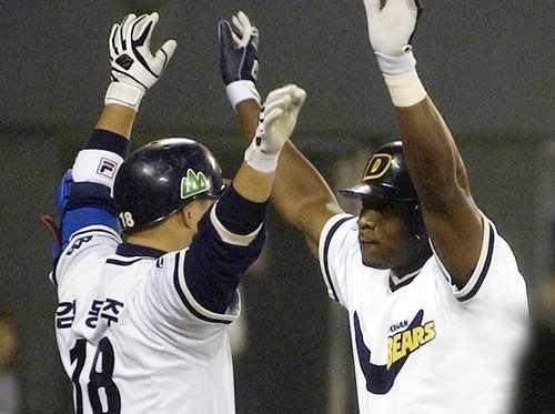 In this file photo from Oct. 24, 2001, Tyrone Woods of the Doosan Bears (R) celebrates with teammate Kim Dong-joo after hitting a solo home run against the Samsung Lions during the bottom of the third inning of Game 3 of the Korean Series at Jamsil Baseball Stadium in Seoul. (Yonhap)
