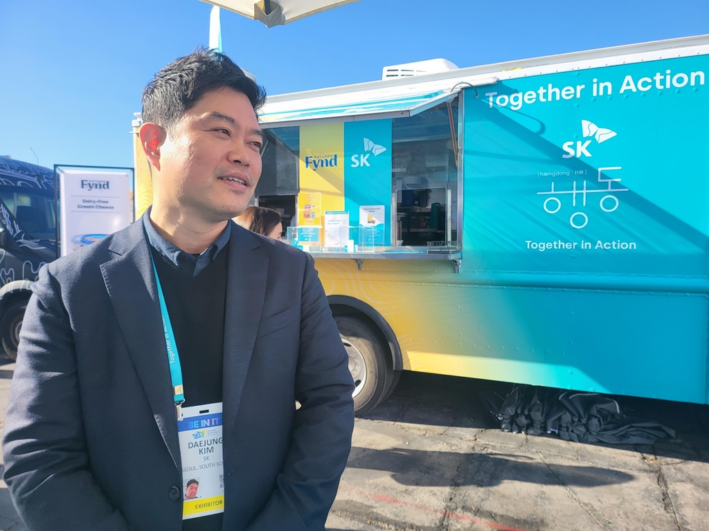 Kim Dae-jung, vice president at SK Inc.'s Green Investment Center, speaks in an interview with Yonhap News Agency next to SK's food truck serving items made with sustainable food, outside the main exhibition hall of CES 2023 taking place in Las Vegas, on Jan. 6, 2023, in this photo provided by the company. (PHOTO NOT FOR SALE) (Yonhap) 