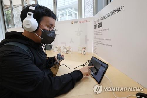 A visitor to a book exhibition held at National Hangeul Museum in Seoul listens to an audiobook on Oct. 6, 2022. (Yonhap)