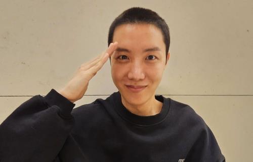 This photo captured from Hybe's Weverse fan community platform shows J-Hope of K-pop boy group BTS giving a salute with a buzz cut. (PHOTO NOT FOR SALE) (Yonhap)