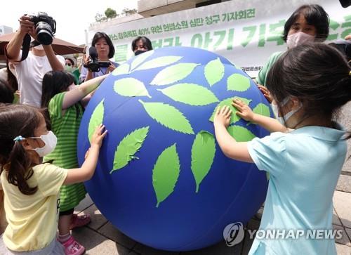 Esta foto de archivo tomada el 13 de junio de 2022 muestra a niños participando en una actuación sobre objetivos netos cero.  (Yonhap)