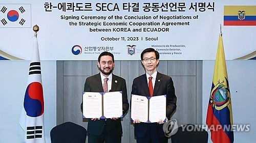 This photo, provided by South Korea's industry ministry, shows South Korea's Industry Minister Bang Moon-kyu (R) and Ecuador's trade minister, Daniel Legarda, posing for a photo after signing a joint statement on the conclusion of negotiations for the bilateral Strategic Economic Cooperation Agreement, a type of free trade deal, in Seoul on Oct. 11, 2023. (PHOTO NOT FOR SALE) (Yonhap)