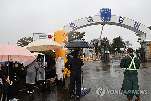 BTS' fans wait for RM and V in rain in front of a military boot camp in Nonsan, South Chungcheong Province, on Dec. 11, 2023. (Yonhap)