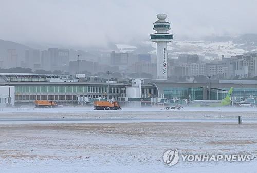 La nieve se está limpiando en el Aeropuerto Internacional de Jeju el 23 de enero de 2024, después de que las fuertes nevadas obligaran a cancelar decenas de vuelos nacionales e internacionales.  (Yonhap)