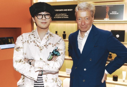 G-Dragon (L), K-pop band BIGBANG's main rapper, poses for photos with Frederic Malle, the founder of the renowned French perfume brand Editions de Parfums Frederic Malle, in this photo provided by Galaxy Corp. (PHOTO NOT FOR SALE) (Yonhap)