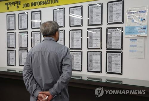 A man looks at job postings at an employment center in Seoul on April 17, 2023. (Yonhap)