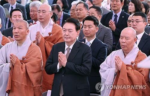 President Yoon Suk Yeol puts his palms together in the Buddhist gesture of prayer at a celebration event marking Buddha's birthday at the Jogye Temple in central Seoul on May 15, 2024. (Yonhap) 