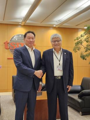 SK Group Chairman Chey Tae-won (L) and Taiwan Semiconductor Manufacturing Co. CEO C.C. Wei shake hands during their meeting in Taiwan on June 6, 2024, in this photo provided by the Korean company. (PHOTO NOT FOR SALE) (Yonhap)