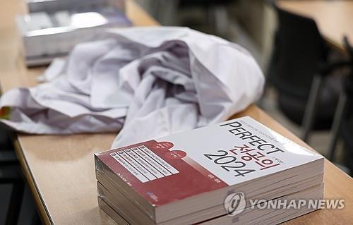 Una bata de médico y libros para el examen nacional para obtener la licencia de médico se encuentran sobre un escritorio dentro de una sala de conferencias en una escuela de medicina en la ciudad de Daegu, al sureste del país, el 6 de septiembre de 2024. (Yonhap)