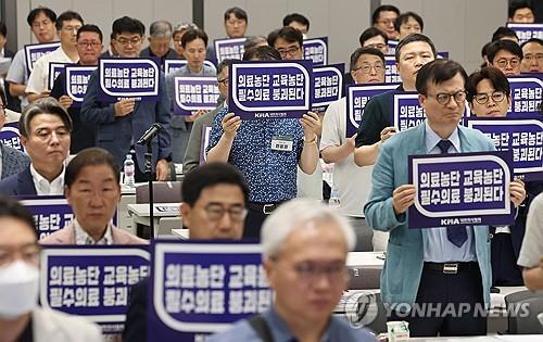 Los participantes en una reunión de emergencia de la Asociación Médica de Corea sostienen carteles en Seúl en protesta por el plan del gobierno de aumentar drásticamente la cuota de admisión a las escuelas de medicina, en esta foto de archivo tomada el 31 de agosto de 2024. (Yonhap)