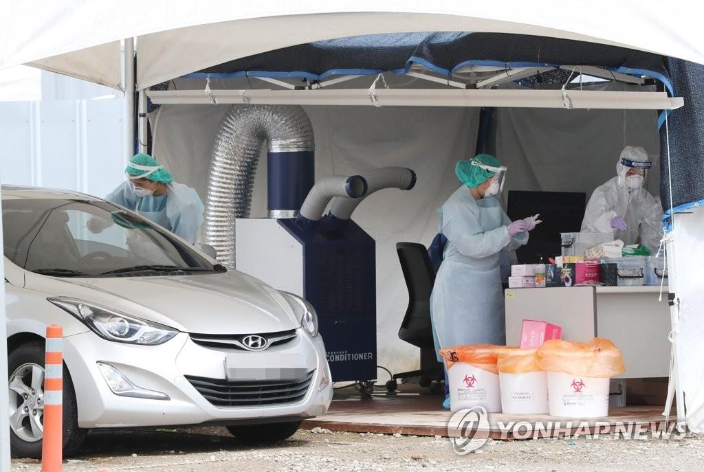 Des agents de santé effectuent des tests de dépistage du Covid-19 dans une clinique temporaire à Séoul, le 28 août 2020.