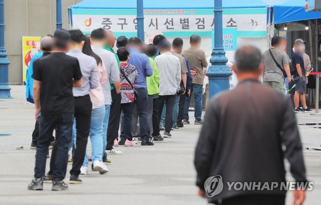 Des citoyens font la queue devant une clinique provisoire de dépistage du nouveau coronavirus (Covid-19) à Séoul, le 7 juin 2021.